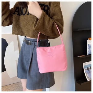 Detailed close-up of a pink nylon shoulder bag featuring the muun and ebony embossed logo