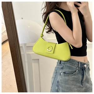 Detail of lime green underarm bag featuring a metallic ring buckle and knotted strap detail