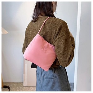Detail of pink nylon shoulder bag featuring milen and ebony logo on minimalist square bag