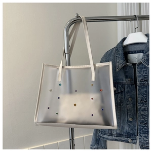 Detail of transparent PVC tote bag with colorful rhinestones and inner pouch