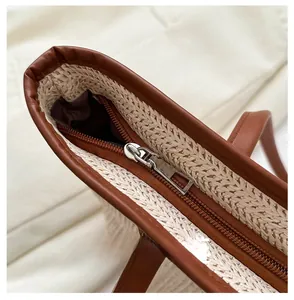 Detail of premium woven tote showing brown leather trim and smooth metal zipper closure