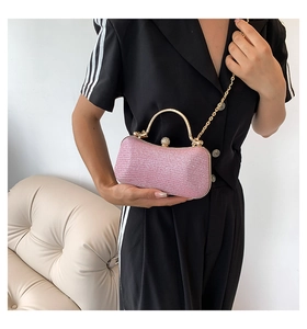 Elegant pink glitter evening clutch with gold metal handle and rhinestone closure detail