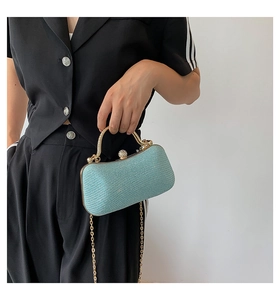 Close-up of light blue glitter clutch with gold handle and rhinestone lock detail