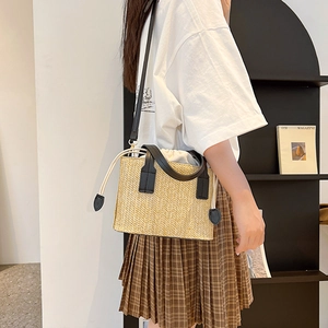 Summer straw crossbody bag with black leather straps and white drawstring closure