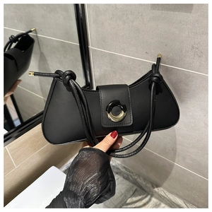 Detail of black PU underarm bag featuring a dual-tone circular metal buckle and knotted strap
