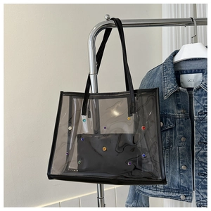 Detail of translucent smoked PVC tote bag with colorful rhinestones and inner pouch