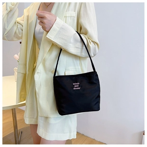 Close-up of a stylish black nylon shoulder bag featuring pink muen and ebony branding