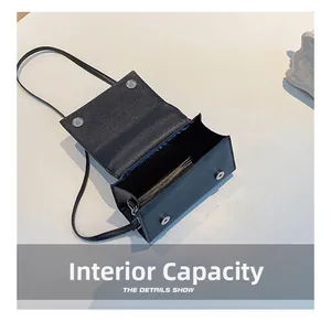Detail view of the black textured leather mini flap bag showing its interior capacity
