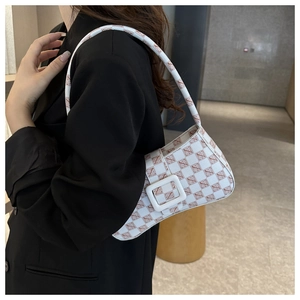 Detail view of a vintage white underarm bag with brown letter patterns on a black blazer