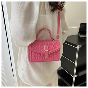 Detail of fuchsia handbag with stone pattern texture and elegant golden buckle