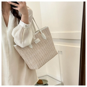 Straw woven tote bag featuring white leather trim and strap shown in a mirror selfie