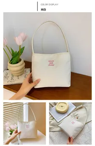 Detailed views of a beige nylon tote bag with pink letter embroidery and interior space