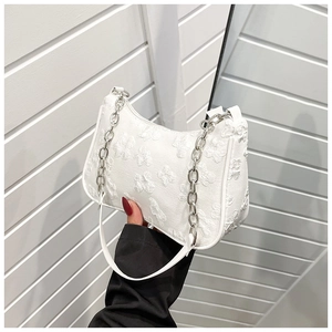Detailed view of white hobo bag with butterfly relief texture and silver chain strap