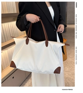Detail of waterproof tote bag with leather handles shown in a professional study setting