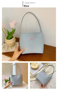 Detail of light blue nylon hobo bag with pink muon and ebony letter embroidery