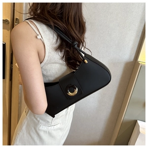 Detail of black matte underarm bag with gold metal buckle and knotted strap on model
