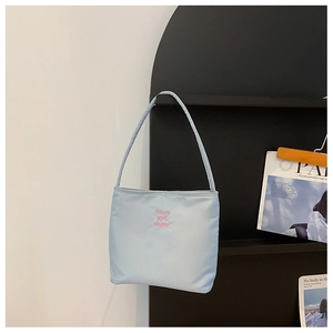 Detail shot of light blue nylon hobo bag featuring pink muon and ebony embroidery