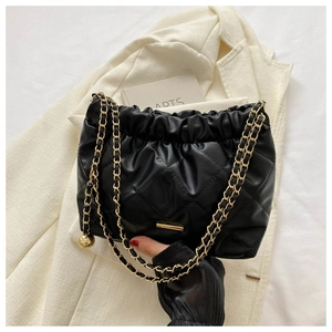 Détail du sac plissé noir avec chaîne dorée et pendentif sphérique élégant en métal