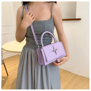 Detail of lavender PU leather square bag with star logo and woven top handle
