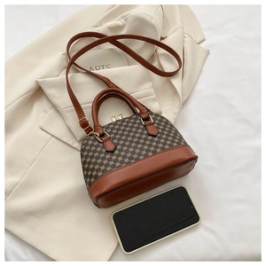 Detail of shell-shaped crossbody bag with vintage chain print and brown leather trim