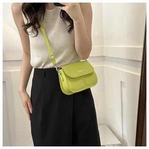 Mirror selfie showing a small avocado green square crossbody bag with Spirit Monday text