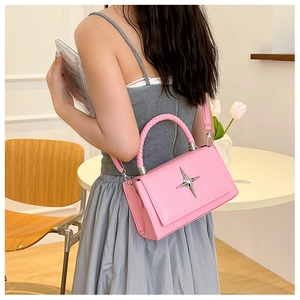 Pink lychee grain leather crossbody bag detail with silver star buckle and woven handle