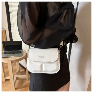 Detail of white leather crossbody bag featuring Fashion Trend EST 1996 printed logo