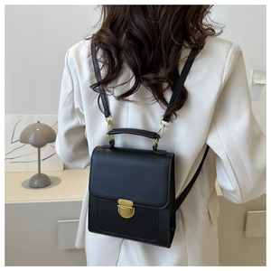 Black leather backpack shown from behind on a model featuring gold hardware and straps