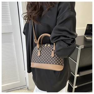 Brown retro pattern shell bag shown as a crossbody purse on a model in a modern room