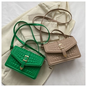 Detail of green and khaki embossed leather purses with golden buckles on fabric