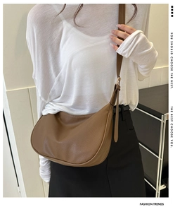 Close-up of brown crescent crossbody bag in pebble grain leather with adjustable strap
