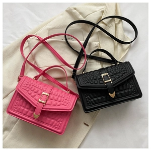 Close-up of stone pattern leather texture on pink and black crossbody bags