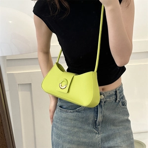 Neon green shoulder baguette bag with gold metal buckle worn by a model in studio