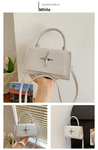 Detailed view of white lychee grain leather crossbody bag with star metal ornament