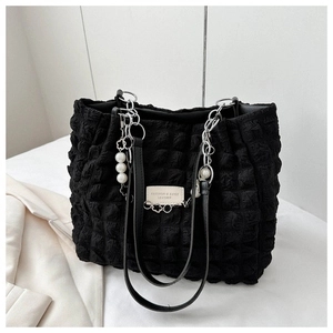 Close-up of black pleated puff tote bag with pearl pendant and silver chain details
