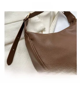 Detail of brown litchi pattern faux leather texture with golden metal hardware buckle