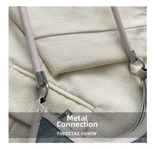 Detailed close-up of blue denim shoulder bag with metal rings and leather trim
