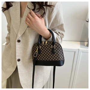 Detail van een vintage mini Boston tas met jacquard patroon en zwart lederen afwerking