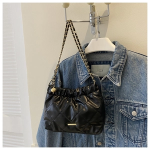 Détail du sac nuage noir plissé avec matelassage en losange et chaîne dorée