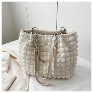 Close-up of cream textured popcorn fabric shoulder bag with pearl flower charms