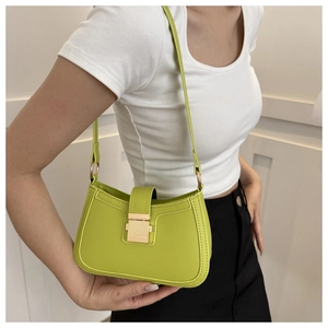 Détail du sac baguette vert citron avec boucle carrée dorée et texture cuir lisse
