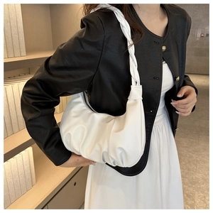 Close-up of white pleated cloud bag featuring a thick braided handle and soft PU leather