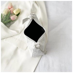 Detail of white floral textured shoulder bag with silver chain strap and black lining