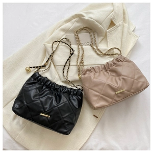 Détail de sacs bandoulière matelassés avec chaînes dorées en noir et beige