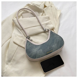Detail of denim hobo bag with contrast leather trim, metal rings and logo print