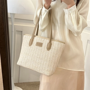 Large straw woven tote bag with leather straps and central logo for summer casual style