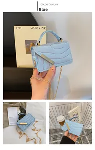 Detailed view of light blue crocodile texture bag with gold metal trim and chain strap