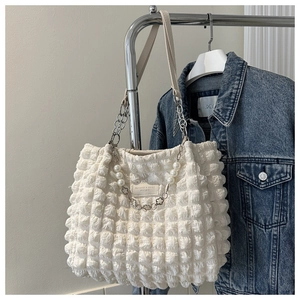 Detail view of white bubble texture tote bag with pearl pendant and silver chain straps