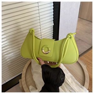 Detail of lime green leather baguette bag featuring a knotted handle and metal ring buckle