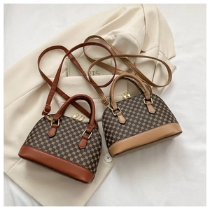 Detail shot of vintage shell bag textures and adjustable shoulder strap on neutral background